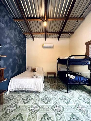 a bedroom with two bunk beds and a tiled floor at Rancho Bonito - Rest & Reset in Tamanique