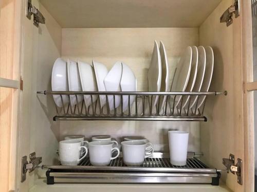 a shelf with dishes and cups and plates on it at Encantador apto en Barrancabermeja in Barrancabermeja