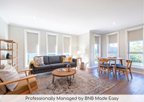 a living room with a couch and a table at Lilly Pilly Lodge - Close to Zoo, 3 Mins to CBD in Dubbo