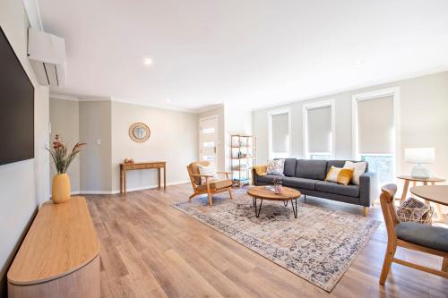 a living room with a couch and a table at Lilly Pilly Lodge - Close to Zoo, 3 Mins to CBD in Dubbo