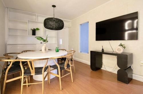 a living room with a table and chairs and a tv at ¡Buen Alma! House in heart of Condesa 8 guests in Mexico City