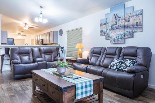 a living room with a leather couch and a table at Sun-Kissed Gem - Pool Heater Golf Green AZ Room in Peoria