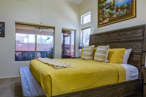 a bedroom with a bed with a yellow blanket at Sun-Kissed Gem - Pool Heater Golf Green AZ Room in Peoria