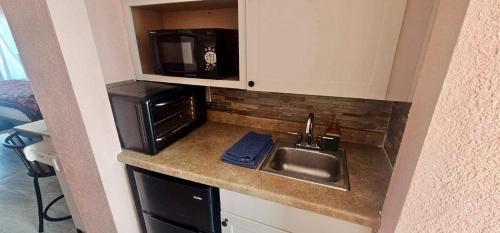 a kitchen counter with a sink and a microwave at Ocean View - Direct Ocean Front-Pool Is Open in Daytona Beach