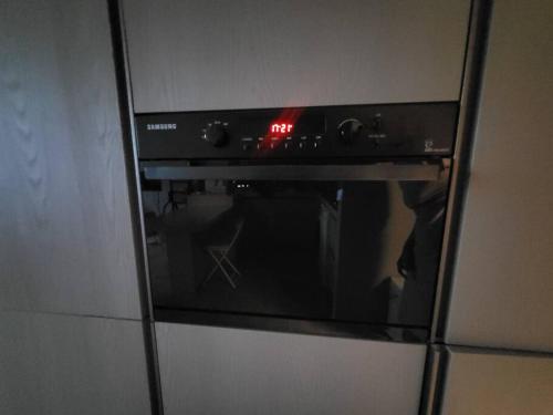 a microwave oven with a red clock on it at House 1 min from Geumjeong St in Gunpo