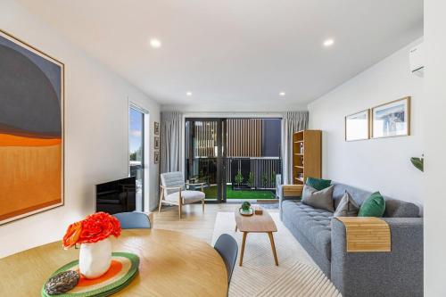 a living room with a couch and a table at Modern 2BR Townhouse in Mission Bay I Zodiak Stays in Auckland