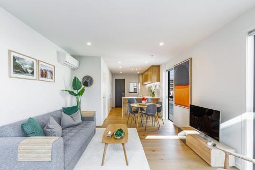 a living room with a couch and a table at Modern 2BR Townhouse in Mission Bay I Zodiak Stays in Auckland