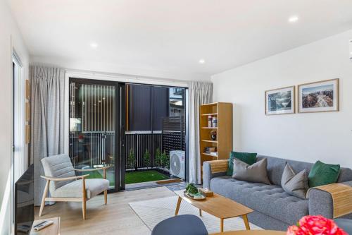 a living room with a couch and a table at Modern 2BR Townhouse in Mission Bay I Zodiak Stays in Auckland
