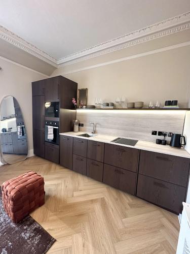 a kitchen with brown cabinets and a wooden floor at Perth City Centre Retreat, 2 Bed in Perth