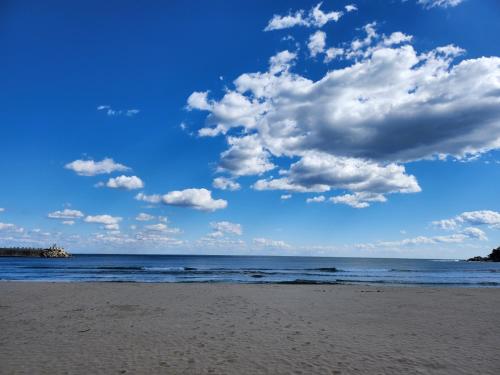 ein Strand mit bewölktem Himmel und dem Meer in der Unterkunft Ocean Stay Yangyang 1318 오션스테이 양양 E7 in Yangyang