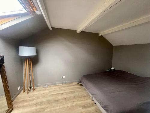 a bedroom with a bed and a lamp in it at Maison proche Paris Stade de France in Aubervilliers