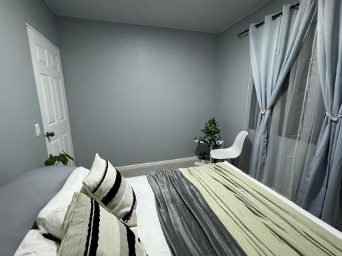 a bedroom with a bed and a chair and a window at B&B Pacuare River Gateway Tica House in Linda Vista