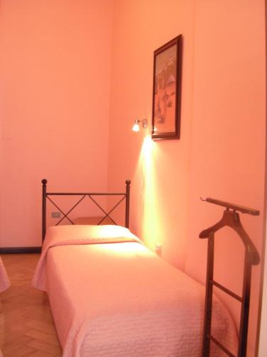 a bedroom with two beds and a light on the wall at Affittacamere Alla Stazione in Trieste