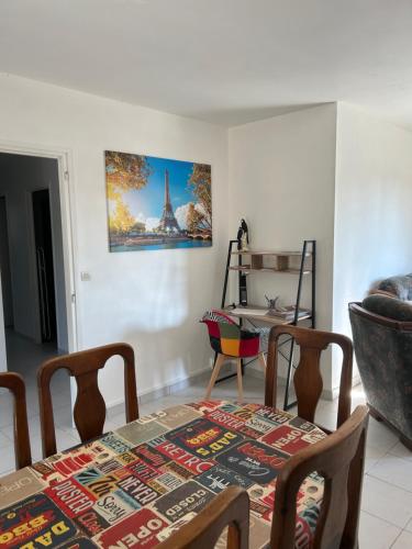 une salle à manger avec une table et une photo sur le mur dans l'établissement La maison du Chef, à Le Blanc