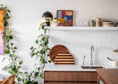 a kitchen with a sink and a shelf with plants at The Artist Retreat 2BR Home 4mins from MCG in Melbourne