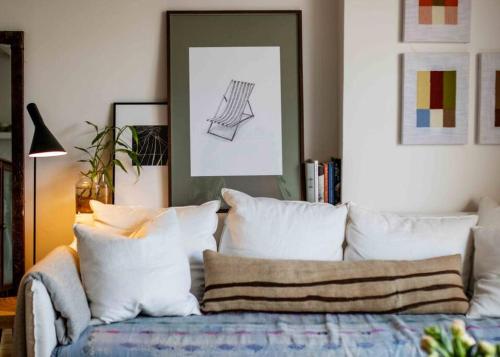 a living room with a couch with white pillows at The Artist Retreat 2BR Home 4mins from MCG in Melbourne
