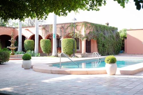 a courtyard with a fountain in front of a building at Hotel Hacienda Cazadores in Navojoa