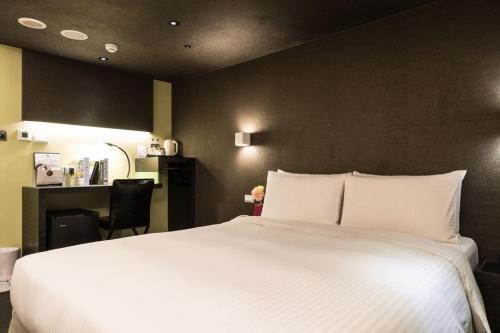 a bedroom with a large white bed and a desk at 凡登台北商務旅店 in Taipei