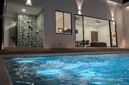 a swimming pool with blue water in a house at The Refuge Your Oasis in Nilo in Nilo