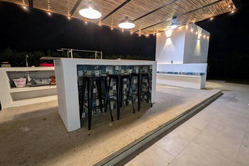 a bar with black stools in the middle of a room at The Refuge Your Oasis in Nilo in Nilo
