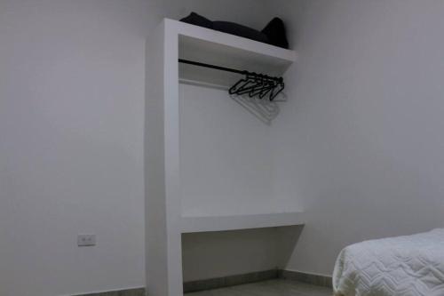 a room with a bed and a white wall at The Refuge Your Oasis in Nilo in Nilo