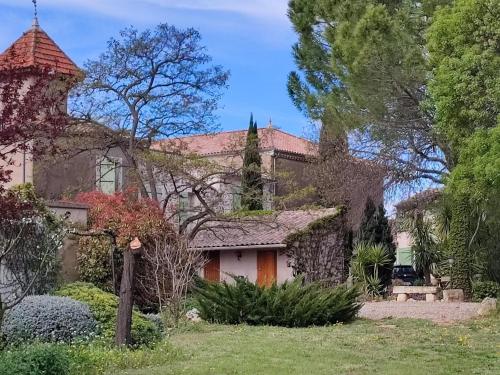 an exterior view of a large house with a tower at Spacious holiday home with private pool and park in Puisserguier