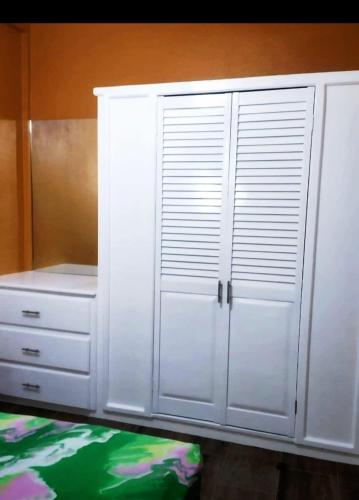 a white closet with white cabinets and a bed at La Bwizan Apts #1 in Laborie