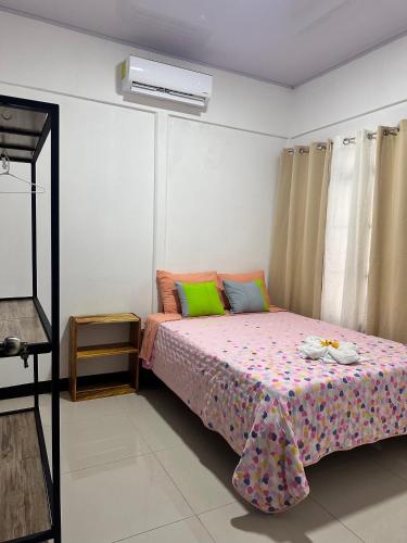 a bedroom with a bed with a flowered bedspread at Casas Najey in Cahuita
