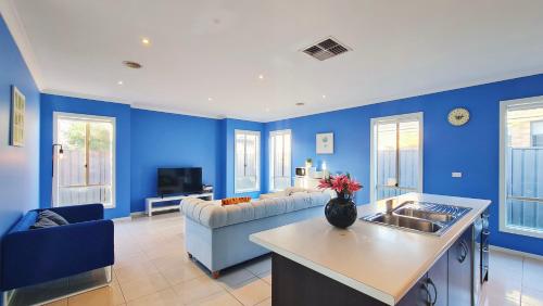 a living room with blue walls and a couch at Blue Home by GoodLive in Morang