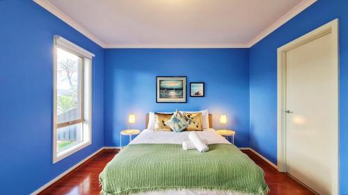 a blue bedroom with a bed and two windows at Blue Home by GoodLive in Morang