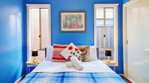 a blue bedroom with a bed and two windows at Blue Home by GoodLive in Morang