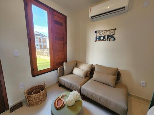 a living room with a couch and a window at Casa 3 Atins in Atins