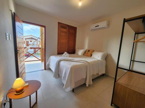 a bedroom with a bed and a large window at Casa 3 Atins in Atins
