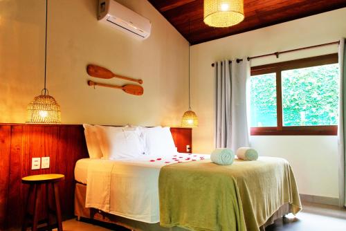 a bedroom with a bed and a window at Tropicália Chalés Boutique in Pipa