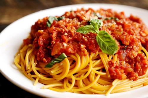 a plate of spaghetti with meat sauce and basil at Chez Maurizio in Villemanoche