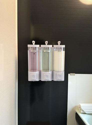 four plastic containers are hanging on a wall at AMP FLAT Tosu in Tosu