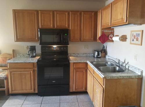 a kitchen with a black stove and a sink at Beaver Creek Inn in Lake Montezuma