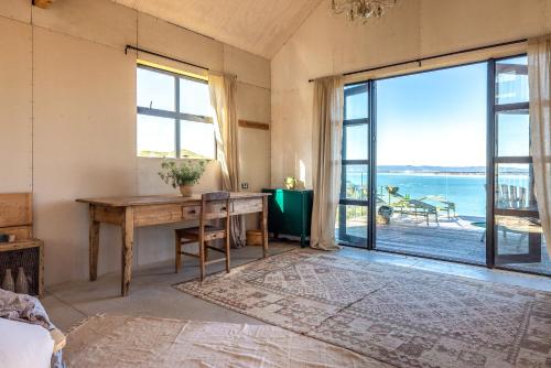 a room with a desk and a large window at Loft & Workroom, Woodside Bay - Be My Guest Waiheke in Rocky Bay