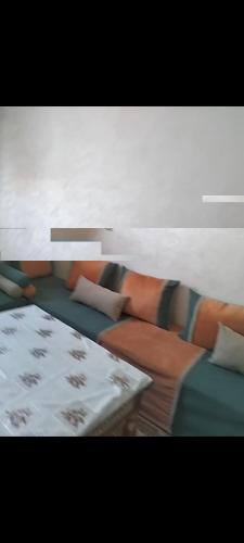 a living room with a couch and a table at Maison bouchra in Oulad Akkou