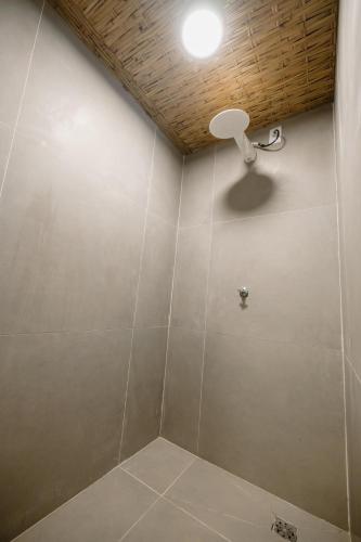 a bathroom with a shower with a light on the wall at Casa Pé na Areia Noronha in Fernando de Noronha