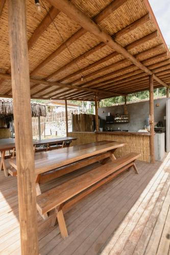 a wooden pavilion with benches on a wooden deck at Casa Pé na Areia Noronha in Fernando de Noronha