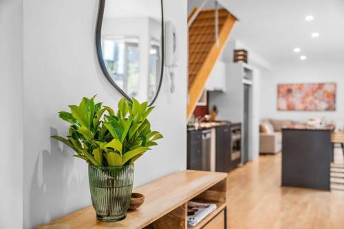 a vase with a plant on a table with a mirror at The Avenue The Place Terrific 4BR 2BTH Townhouse in Melbourne