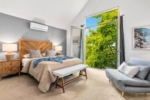 a bedroom with a bed and a chair and a window at The Avenue The Place Terrific 4BR 2BTH Townhouse in Melbourne