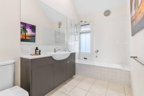 a bathroom with a sink and a tub and a toilet at The Avenue The Place Terrific 4BR 2BTH Townhouse in Melbourne