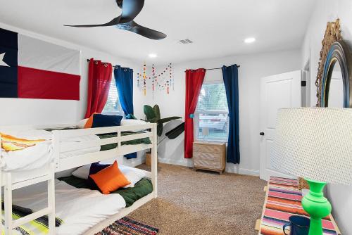 1 Schlafzimmer mit 2 Etagenbetten und einem Deckenventilator in der Unterkunft LaTexienda - 7min to A&M - Firepit - Volleyball - BBQ in College Station