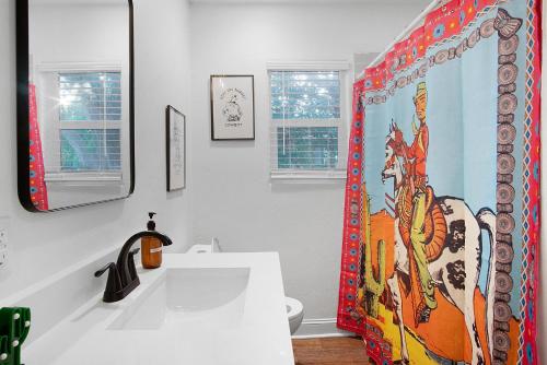 ein Badezimmer mit Waschbecken und Duschvorhang in der Unterkunft LaTexienda - 7min to A&M - Firepit - Volleyball - BBQ in College Station