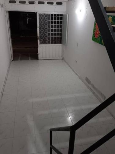 a room with a white tile floor and a chair at Acogedor apartamento familiar in Mariquita