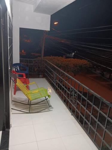 two chairs sitting on a balcony at night at Acogedor apartamento familiar in Mariquita