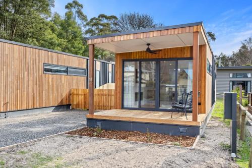 a house with a glass door and a chair in it at Small Scale Stays - Couples Retreats in Halls Gap