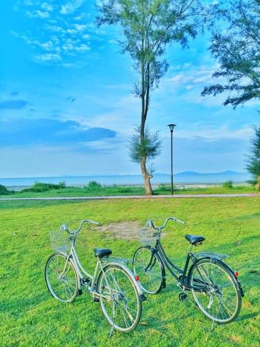 two bikes parked in the grass in a field at Happy vacation homestay mersing in Mersing